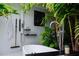 Outdoor bathroom showcasing a modern tub, sleek fixtures, and tropical foliage for a serene setting at 440 64Th Ave, St Pete Beach, FL 33706