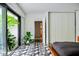 Modern bedroom with geometric tile flooring, sleek wardrobe, and lush plants near the sliding glass doors at 440 64Th Ave, St Pete Beach, FL 33706