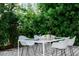 Outdoor dining area featuring a modern white table and chairs surrounded by lush greenery for private meals at 440 64Th Ave, St Pete Beach, FL 33706