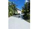 Long driveway leads to a modern home, framed by lush, tropical landscaping at 440 64Th Ave, St Pete Beach, FL 33706