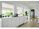 Bright kitchen with white cabinets, marble counters, stainless steel appliances, and dining area at 440 64Th Ave, St Pete Beach, FL 33706