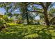 Spacious backyard with lush lawn, mature trees, and serene water views at 4244 Tamargo Dr, New Port Richey, FL 34652