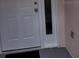 White front door with sidelight and small mat at 2367 N Bentley Dr, Palm Harbor, FL 34684