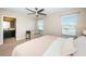 King bedroom with ceiling fan, en-suite bathroom access and sitting area at 12610 Rangeland Blvd, Odessa, FL 33556