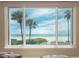 Stunning ocean view from large window, showing beach and palm trees at 19106 Gulf Blvd # 102, Indian Shores, FL 33785