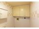 Small laundry room with upper cabinets and tiled walls at 707 1St Ct, Palm Harbor, FL 34684