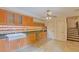 Kitchen with wood cabinets, granite counters, and access to the stairs at 707 1St Ct, Palm Harbor, FL 34684