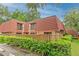 Townhouse with red tile roof, fenced yard, and lush landscaping at 707 1St Ct, Palm Harbor, FL 34684