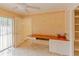 Home office with wood desk, built-in shelves, and patio access at 707 1St Ct, Palm Harbor, FL 34684