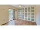 Bedroom with wood floors and sliding glass doors to balcony at 707 1St Ct, Palm Harbor, FL 34684