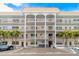 Exterior of building with covered balconies, palm trees, landscaping and parking at 3128 59Th S St # 214, Gulfport, FL 33707