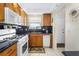 Charming kitchen boasts wood cabinets, white appliances, and dark countertops providing an inviting space at 3128 59Th S St # 214, Gulfport, FL 33707