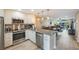 Open concept kitchen features granite island, stainless steel appliances, and light cabinets at 175 116Th Ave # 102, Treasure Island, FL 33706