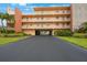 Modern condo building with parking garage and lush landscaping at 175 116Th Ave # 102, Treasure Island, FL 33706