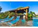 Relaxing pool area with covered seating and lounge chairs at 7050 Sunset S Dr # 203, South Pasadena, FL 33707