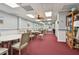 Inviting community room with tables, chairs, and a bookcase at 7050 Sunset S Dr # 203, South Pasadena, FL 33707