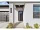 Modern front entrance with black door and landscaping at 7453 Blackhawk Trl, Spring Hill, FL 34606