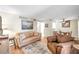 Living room with light brown couches and wood floors at 8911 Blind Pass Rd # 209, St Pete Beach, FL 33706