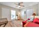 Cozy living room with a red couch, ceiling fan, and access to balcony at 8911 Blind Pass Rd # 209, St Pete Beach, FL 33706