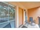 Covered balcony with seating area and sliding glass doors at 8911 Blind Pass Rd # 209, St Pete Beach, FL 33706