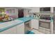 Modern kitchen with stainless steel appliances and teal countertops at 308 Mariner Dr # 308, Tarpon Springs, FL 34689