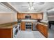 Kitchen with stainless steel appliances, wood cabinets, and a washer/dryer at 3455 41St S Ter # 208, St Petersburg, FL 33711