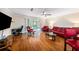 Living room with hardwood floors, red leather furniture, and access to a patio at 3455 41St S Ter # 208, St Petersburg, FL 33711