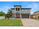Beautiful two-story house with a red door, gray siding and a paved driveway at 6016 82Nd N Ter, Pinellas Park, FL 33781