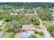 Aerial view showing a house surrounded by lush greenery and neighboring homes at 1950 Lillian Ave, Tarpon Springs, FL 34689