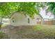 Tan house exterior, side yard with wooden fence and grass at 1950 Lillian Ave, Tarpon Springs, FL 34689