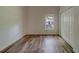 Bedroom with wood-look floors, window, and double-door closet at 1950 Lillian Ave, Tarpon Springs, FL 34689