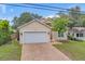 Two-story home with a white garage door and brick driveway at 1950 Lillian Ave, Tarpon Springs, FL 34689