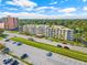 Exterior view of condo building with rows of balconies, parking lot, and tree-lined street at 1200 N Shore Ne Dr # 301, St Petersburg, FL 33701