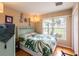 Bedroom with a teal bed frame and leafy bedding, featuring a window with a view at 22607 Southshore Dr, Land O Lakes, FL 34639