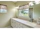 Double vanity bathroom with granite countertop and oval mirrors at 22607 Southshore Dr, Land O Lakes, FL 34639