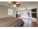 Main bedroom with hardwood floors, a striped comforter, and access to a balcony at 22607 Southshore Dr, Land O Lakes, FL 34639