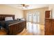 Bedroom with dark wood bed frame and direct access to backyard at 22607 Southshore Dr, Land O Lakes, FL 34639