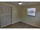 Bright bedroom with wood-look floors, window, and closet at 6731 Sandra Dr, Port Richey, FL 34668