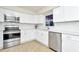 Modern kitchen with white shaker cabinets, stainless steel appliances, and quartz countertops at 10617 N 27Th St, Tampa, FL 33612