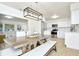 Farmhouse dining table with bench seating, stylish lighting, and open concept to living room at 10617 N 27Th St, Tampa, FL 33612