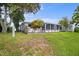 View of the backyard featuring a patio, lush lawn, and mature trees at 4035 Glissade Dr, New Port Richey, FL 34652