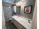 Modern bathroom with white vanity, marble countertop, and grey tile at 1604 Whitebridge Dr # A, Palm Harbor, FL 34684