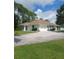 Single-story home with a large driveway and landscaped lawn at 1318 Manasota Beach Rd, Englewood, FL 34223