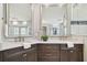 Elegant bathroom features double sinks, marble countertops, decorative mirrors, and stylish dark wood cabinetry at 19820 Gulf Blvd # 401, Indian Shores, FL 33785