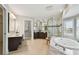 Bright bathroom with double sinks, soaking tub, glass enclosed shower and water closet at 19820 Gulf Blvd # 401, Indian Shores, FL 33785