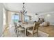 Bright dining room features a chandelier, a modern table setting, and ocean views perfect for elegant gatherings at 19820 Gulf Blvd # 401, Indian Shores, FL 33785