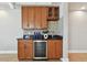 Stylish wet bar area featuring wooden cabinets, mosaic backsplash, and a wine refrigerator, perfect for entertaining at 19820 Gulf Blvd # 401, Indian Shores, FL 33785
