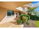 Charming condo entrance featuring lush greenery, a small palm tree, and the unit number 114 at 5095 Bay Ne St # 114, St Petersburg, FL 33703