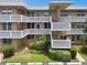 Tan condo building with block white railings, stairs, and neatly trimmed landscaping, and visitor parking at 5095 Bay Ne St # 114, St Petersburg, FL 33703