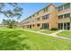 Condo exterior with grassy area and an arrow pointing towards entrance at 5095 Bay Ne St # 114, St Petersburg, FL 33703